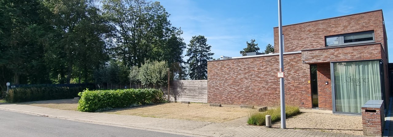 Overzicht van de parking links en de ingang van Atelier Aimée rechts